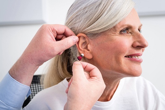 Ältere Frau erhält ein modernes Hörgerät für besseres Hören und mehr Lebensqualität.